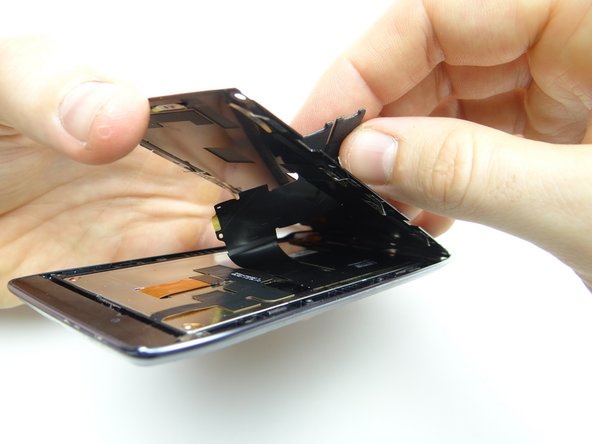 Pictures 2 &amp; 3: Lift the bottom of metal plate away from display assembly, treating the top as a hinge while simultaneously feeding display cable through.