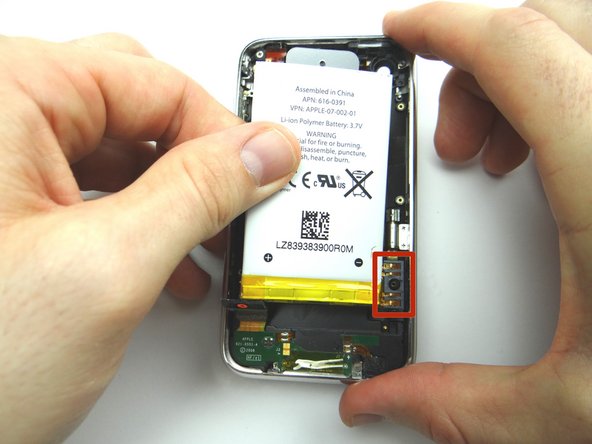 Place the battery in the rear case: seat the contact pad first, then continue seating the battery.