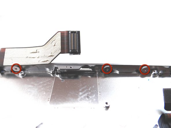 Picture 3: Loosen the three large-head Phillips screws along the right side of the iPhone about one half turn, taking care not to remove these screws.