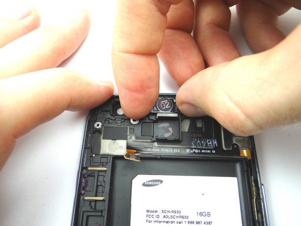 Pick up the earpiece speaker with your thumb and index finger and gently pull the ribbon cable up from left to right.