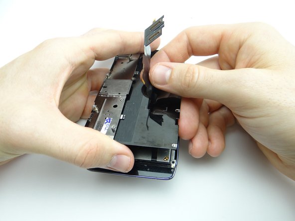 Pictures 2 &amp; 3: Lift the bottom of metal plate away from display assembly, treating the top as a hinge while simultaneously feeding display cable through.