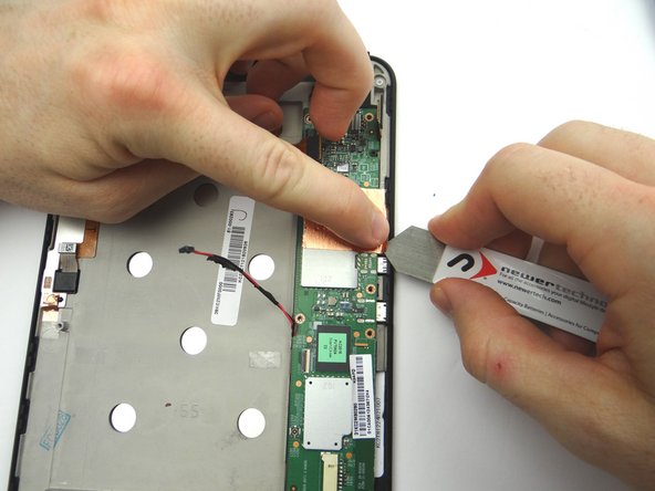 Picture 2: Peel up the corner of the copper tape with the iSesamo in one hand, while protecting the logic board from contact with the iSesamo tool with your pointer finger on the opposite hand.