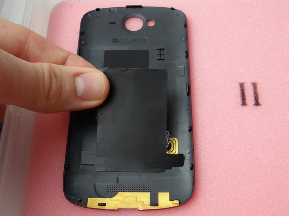 Place it on the inside of the battery cover in ZONE I, sticky side down.