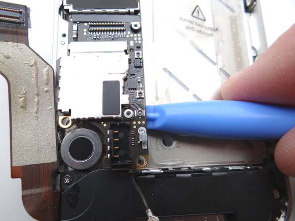 Picture 1: Using the blue pry tool, carefully lift the logic board just high enough to pinch it with your left thumb and index finger.