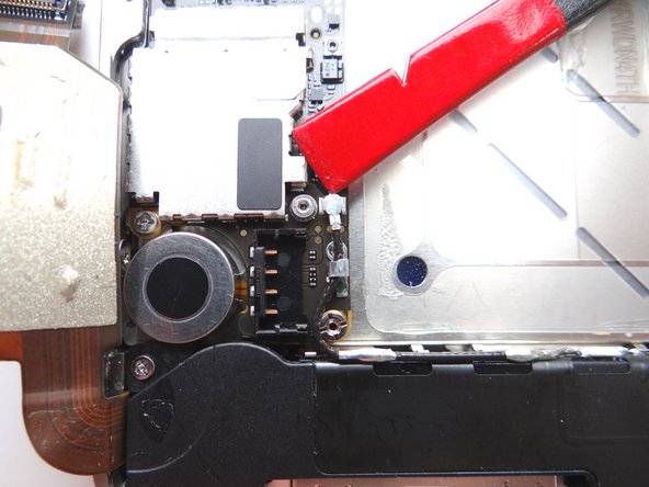 Picture 1: Place Black Spudger under cellular antenna connector. Gently lift to release antenna from its socket on the logic board.