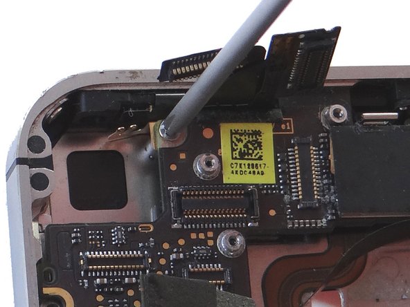 Picture 1: There may be a small piece of black electrical tape covering the pictured screw.  If it's there use Plastic Tweezers to remove and discard it.