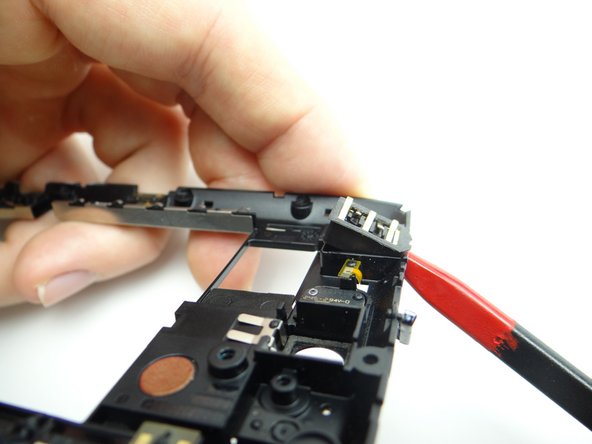 The headphone jack is attached to the interior of the mid-frame.  Use the pointed end of the spudger to rotate the headphone jack away from its socket.