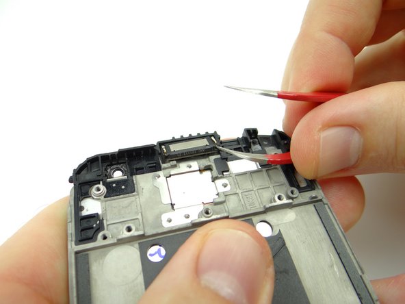 There's a tiny notch in either of the exposed corners of the earpiece speaker: