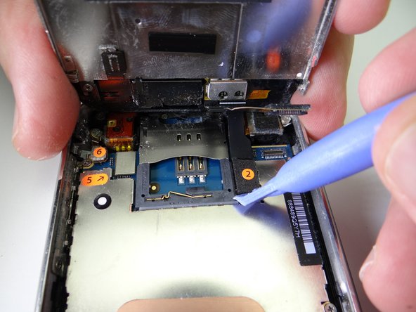 Picture 1: Use blue pry tool to lift cable 2 from its socket.  You can now open the phone to a 90* angle.