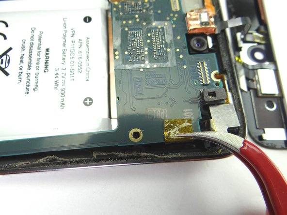 Picture 1: Use curved-tip tweezers to carefully remove the yellow tape that wraps around to the rear camera cable.