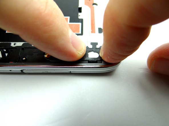 Picture 3: Seat the home button from COMPARTMENT C: first feed home button cable through mid-frame, then position home button on mid-frame.