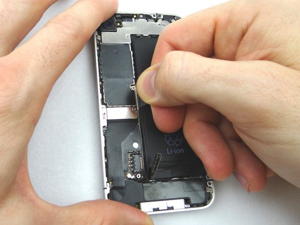 Once loose, use the plastic pull tab to peel the battery free from the iPhone. Place the battery in ZONE II