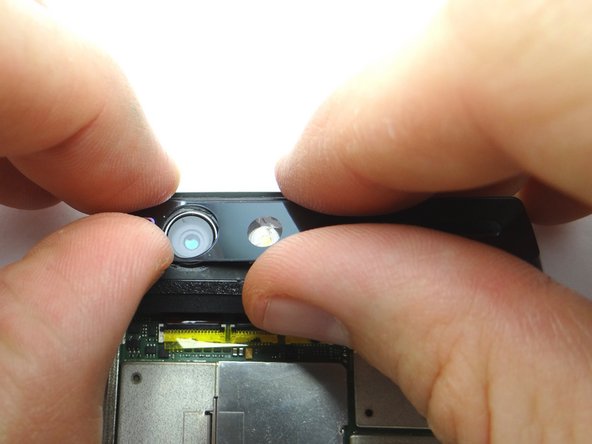 Retrieve the rear camera trim from COMPARTMENT C.  Starting from the left side, reapply the rear camera trim and press firmly to resecure it to the phone.