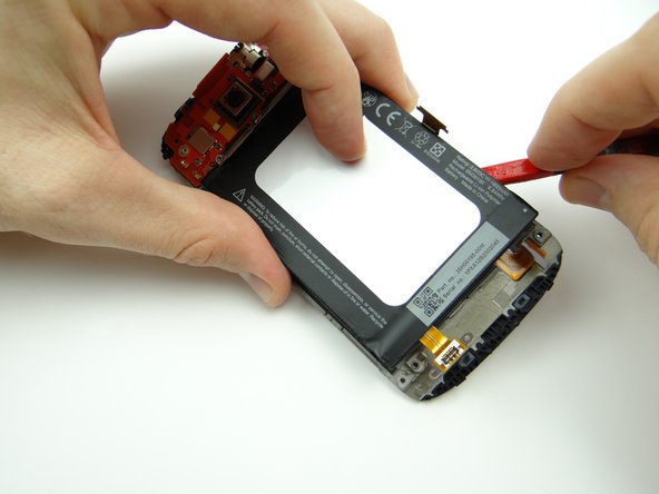 Use the spudger to work your way up the right side of the battery until it's free.