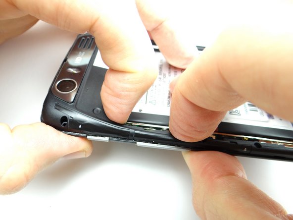 Pictures 2 &amp; 3: Pivot the volume rocker on the mid-frame around the volume rocker tabs on the logic board, then snap this area of the mid-frame into place first.