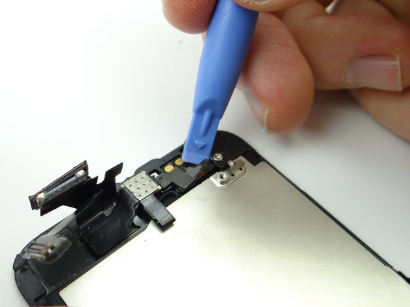Picture 1: Wedge the blue pry tool under the right edge of the front-facing camera cable.