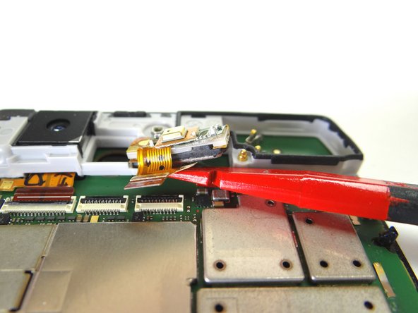 Picture 2: Wedge the spudger under the microphone / earpiece speaker assembly and pry up.