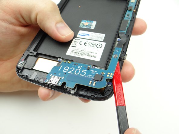 Pictures 2 &amp; 3: Slowly work up the charging port assembly to free it from the mild adhesive holding it in place.