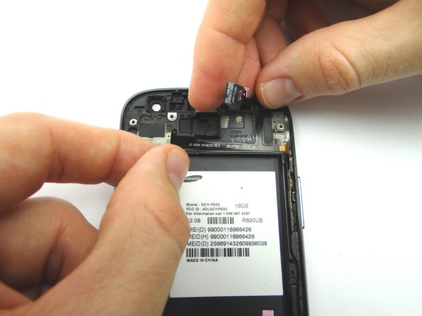 Grab the ribbon cable near the connector on the left side and gently lift it from the phone, going left to right.