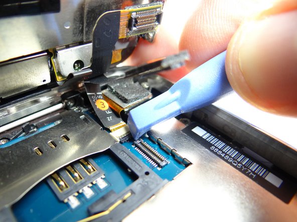 Picture 3: Use the blue pry tool to sweep down black swing bar to close ZIF connector.