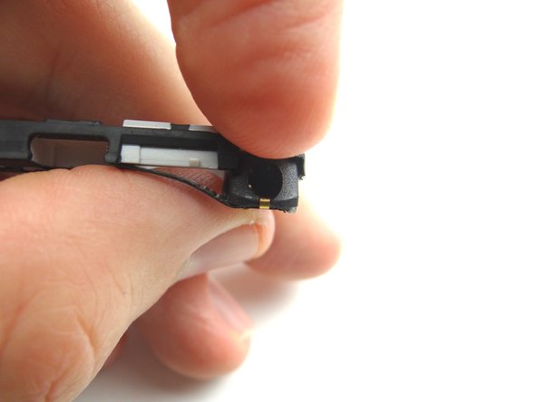 Use the pointed tip of the spudger to pry the headset jack free from the antenna bracket.