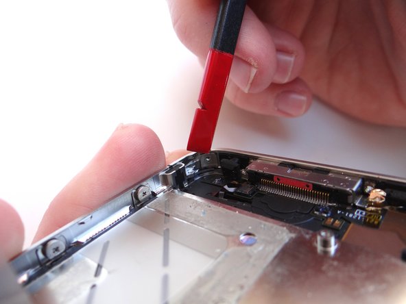 Picture 2: Wedge the metal iSesamo between the display assembly and mid-frame at the bottom-right of the phone.