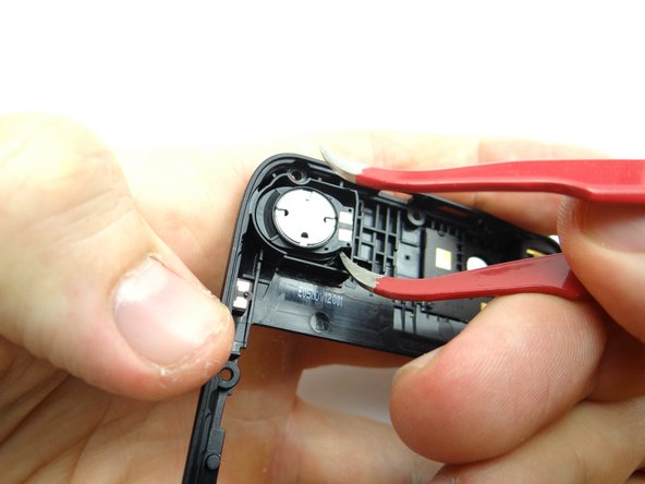 Use a single prong of the curved-tip tweezers to wedge under the loudspeaker and lift it away from the mid-frame.  Place loudspeaker in COMPARTMENT B.