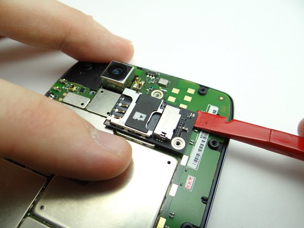 Wedge the flat end of the spudger under the upper-right corner of the SIM/SD card tray.  Gently lift the tray out of its socket.