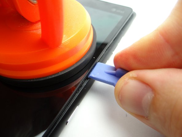 Pictures 2 &amp; 3: Pull up the screen slightly while wedging the blue pry tool in the center of the right side, between the display assembly bezel and rear case.