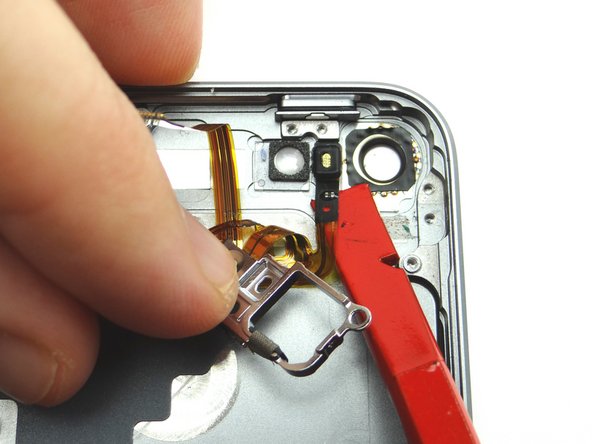 Insert the spudger at the bottom of the microphone and push it  up to free it from the rear case.