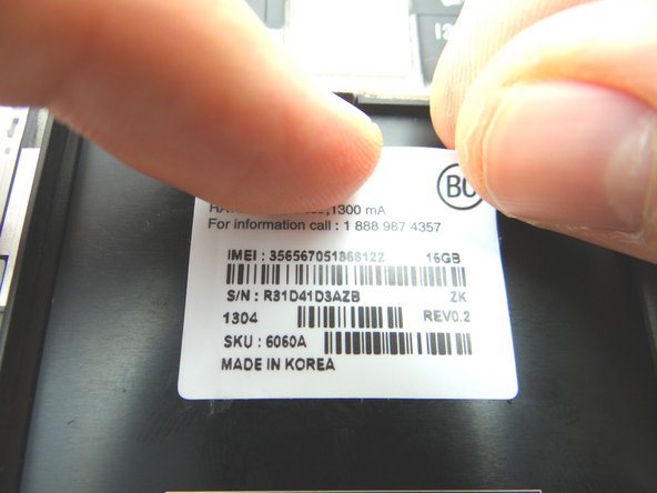 Use your finger nail or tweezers to lift the corner of the sticker and peel up.  Move it immediately to the replacement part.