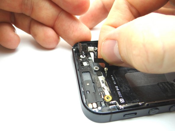 Picture 1: Use your fingers to start pulling the ribbon cable off of the rear case, starting from right to left.