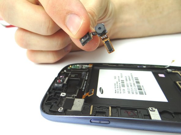 Use your fingers to grasp the front-facing camera and lift from left to right to peel up the ribbon cable that is attached. Place it in COMPARTMENT B.