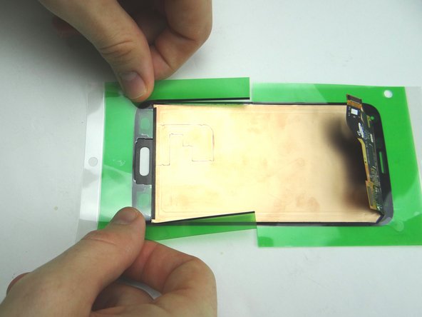 Remove the inner backing labelled '1' from the bottom half of the adhesive. Seat the bottom half of the adhesive on the screen.