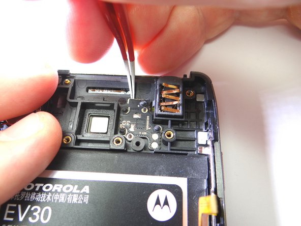 Wedge the curved-tip tweezers in the closed position under the camera flash. Pry up to free it.