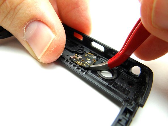 Picture 2: Wedge the curved-tip tweezers in the closed position under the camera flash. Pry up to free it.