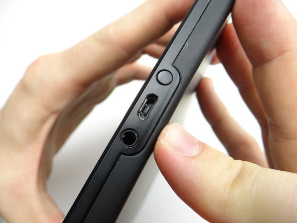 Start with the two tabs on either side of the charging port.