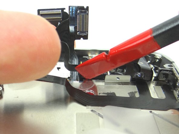 Picture 1: Wedge the Black Spudger underneath the ribbon cable beneath the speaker (held by adhesive). Gently pry upwards.
