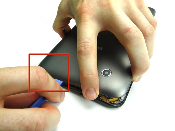 Picture 2: Bring the cover back down until it's nearly flat.  Work your way around the corner with the blue pry tool to finish separating the battery cover from the front panel.