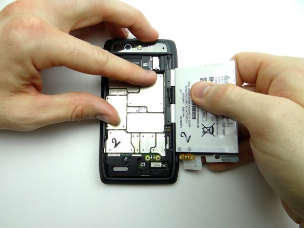 Fold the battery away from the phone, opening it like a book.