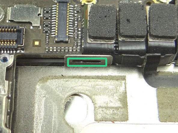 Picture 2: Position the protruding tabs at the bottom of the Cable Shield into the slots on the EMI Shield (connected to the logic board) below.