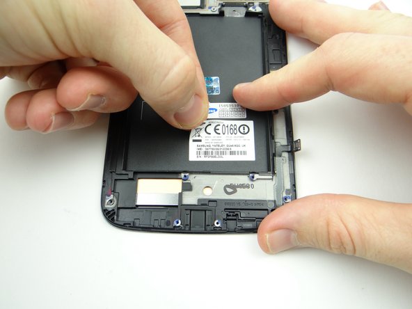 Pictures 2 &amp; 3: Use curved-tip tweezers to pinch the upper-left corner of the IMEI sticker and lift the corner.  Pinch the sticker with your fingers and remove it.