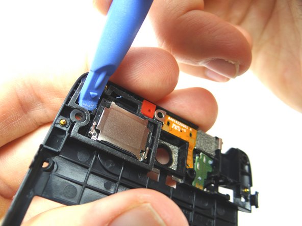 Picture 1: Wedge blue pry tool under upper-left corner of loudspeaker.