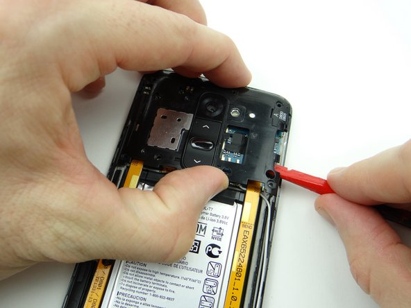 Wedge the flat end of the spudger under the right edge of the rear housing.  Slowly twist the spudger while lifting the housing with your fingers.