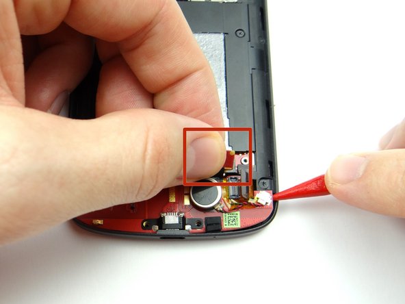 Gently pull up on the charging port board cable (red square) while using the pointed tip of the spudger to wedge under the board and lift.