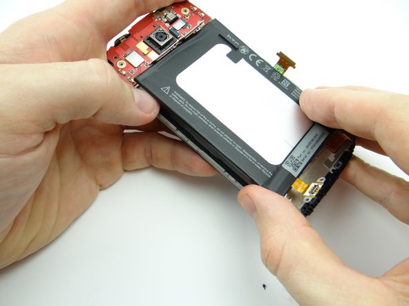 Picture 2: Wedge the flat end of the spudger where you inserted the guitar pick.  Work your way up the left side to separate the adhesive