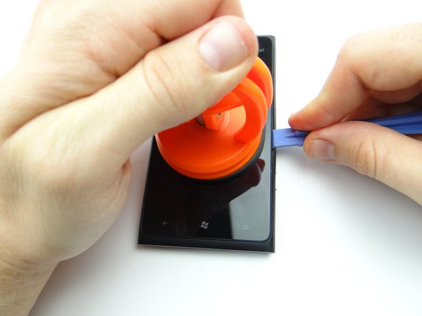 Pictures 2 &amp; 3: Pull up the screen slightly while wedging the blue pry tool in the center of the right side, between the display assembly bezel and rear case.