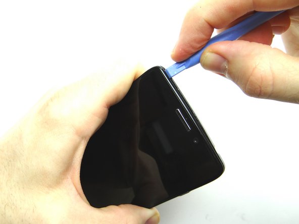 Picture 2: Insert blue pry tool in the upper-left corner, then work your way across the top edge.