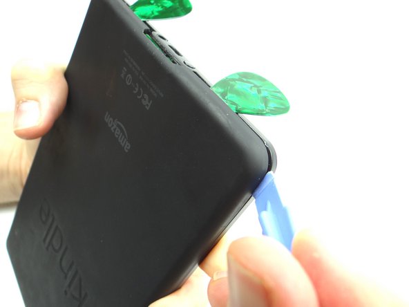 Pry from the bottom of the Kindle to the top to release the battery cover clips.