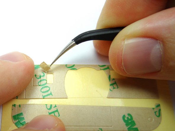 Picture 1: Prepare new adhesive by removing the cutout portions with Curved Tip Tweezers.